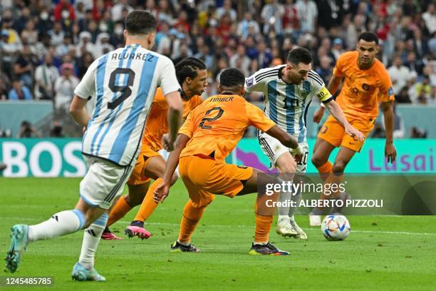 Argentina's forward Lionel Messi is marked before assisting Argentina's defender Nahuel Molina to score his team's first goal during the Qatar 2022...