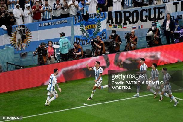 Argentina's defender Nahuel Molina celebrates with teammates after he scored his team's first goal during the Qatar 2022 World Cup quarter-final...