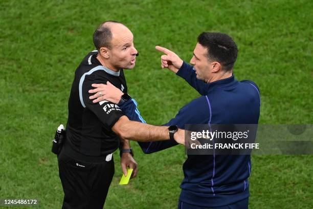 Argentina's coach Lionel Scaloni argues with Spanish referee Antonio Mateu received a yellow card during the Qatar 2022 World Cup quarter-final...