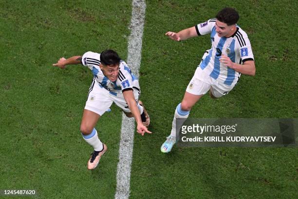 Argentina's defender Nahuel Molina celebrates with Argentina's forward Julian Alvarez after he scored his team's first goal during the Qatar 2022...