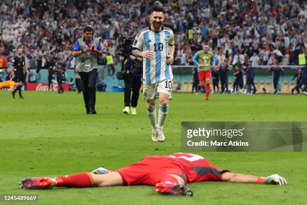 Argentina's Lionel Messi runs towards Damian Martinez after winning the penalty shootout of the FIFA World Cup Qatar 2022 quarter final match between...