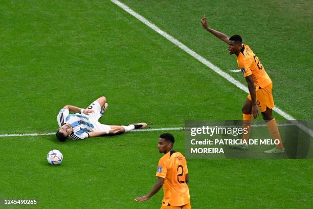 Netherlands' defender Denzel Dumfries reacts after he committed a foul on Argentina's defender Marcos Acuna during the Qatar 2022 World Cup...