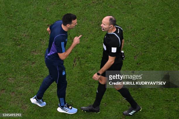 Argentina's coach Lionel Scaloni argues with Spanish referee Antonio Mateu after he received a yellow card during the Qatar 2022 World Cup...