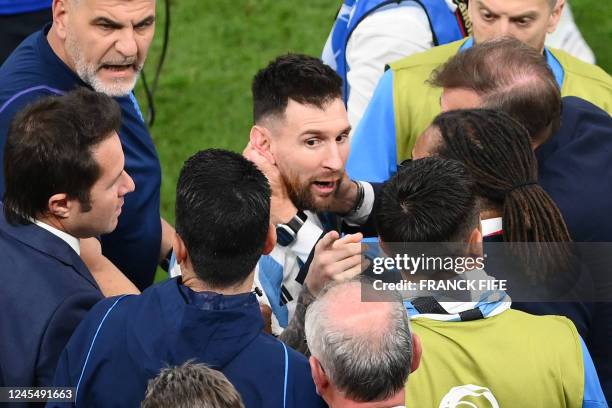 Argentina's forward Lionel Messi speaks with former Netherlands player Edgar Davids as he celebrates winning the Qatar 2022 World Cup quarter-final...