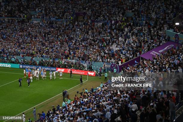 General view shows Argentina players celebrating with their supporters after they won the Qatar 2022 World Cup quarter-final football match between...