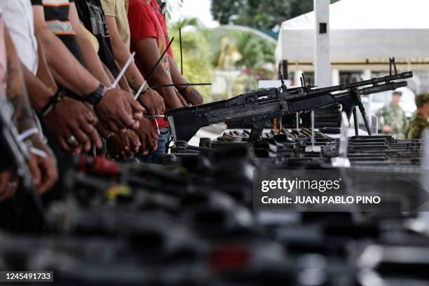 Captured FARC dissidents remain handcuffed by weapons seized from them during a military operation in Tumaco, southern Colombia, on December 9, 2022....