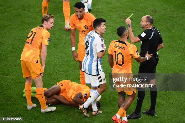 Argentina's defender Marcos Acuna receives a yellow card from Spanish referee Antonio Mateu during the Qatar 2022 World Cup quarter-final football...