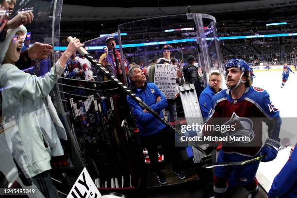 Samuel Girard of the Colorado Avalanche gives a stick to a fan prior to the game against the New York Rangers at Ball Arena on December 9, 2022 in...