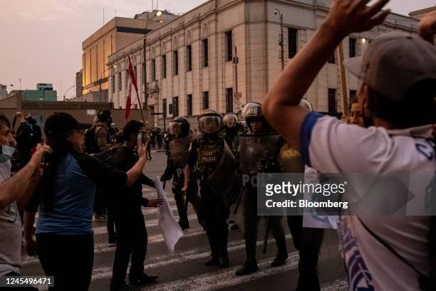 Riot police officers move towards supporters of Pedro Castillo, Peru's former president, at they protest his impeachment and arrest on Avenida...