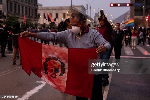 Supporter of Pedro Castillo, Peru's former president, holds a bloodied Peruvian national flag while protesting his impeachment and arrest on Avenida...