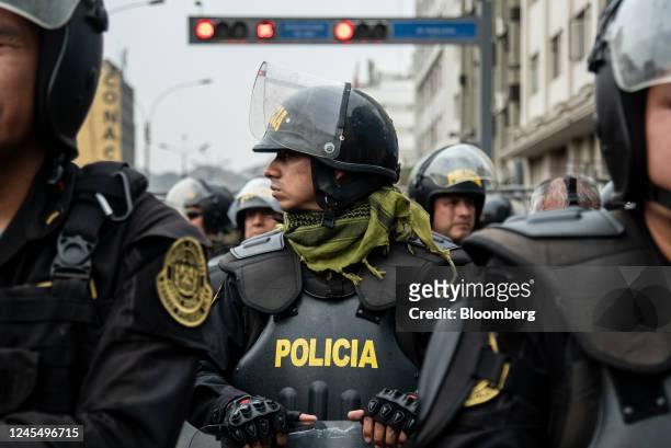 Riot police officers hold a line as supporters of Pedro Castillo, Peru's former president, protest his impeachment and arrest on Avenida Abancay in...