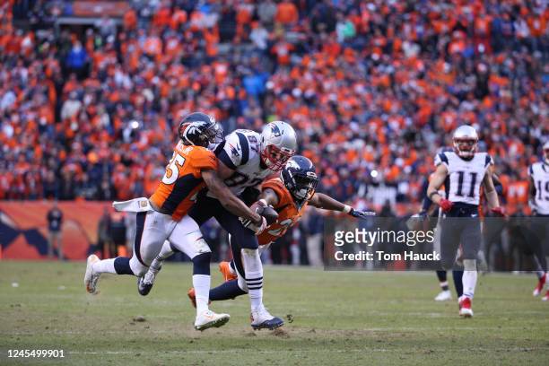 New England Patriots tight end Rob Gronkowski catches a pass over Denver Broncos cornerback Chris Harris and Denver Broncos defensive back Josh Bush...
