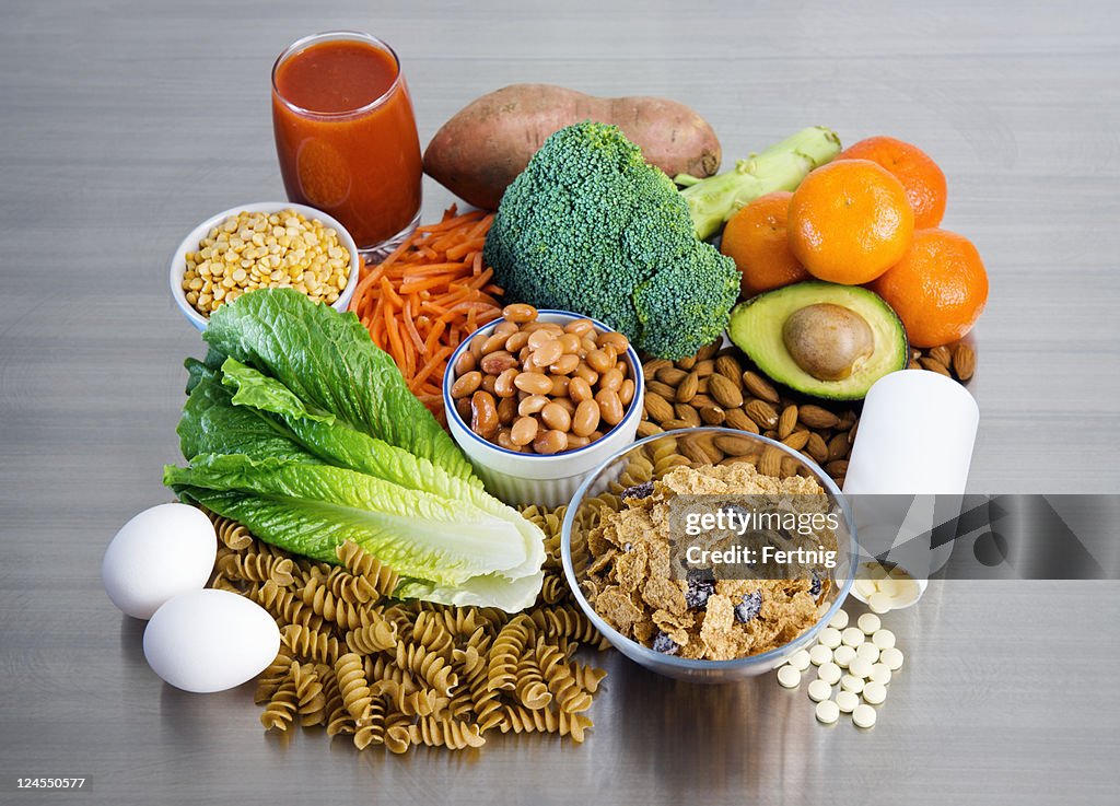 Folic Acid supplement and foods on stainless kitchen counter