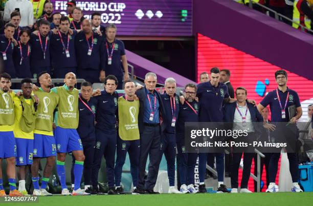 Brazil manager Tite stands with his back rooms staff and players as they look on during the penalty shootout following the FIFA World Cup...