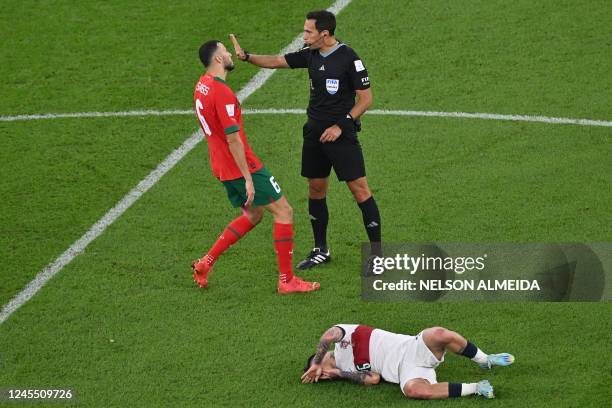 Morocco's defender Romain Ghanem Saiss argues with Argentine referee Facundo Tello after Morocco's midfielder Sofiane Boufal fouled Portugal's...