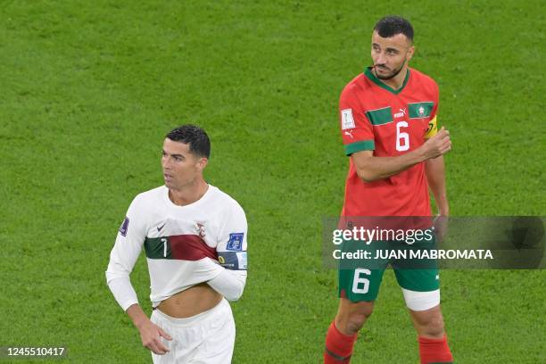 Portugal's forward Cristiano Ronaldo gestures next to Morocco's defender Romain Ghanem Saiss during the Qatar 2022 World Cup quarter-final football...