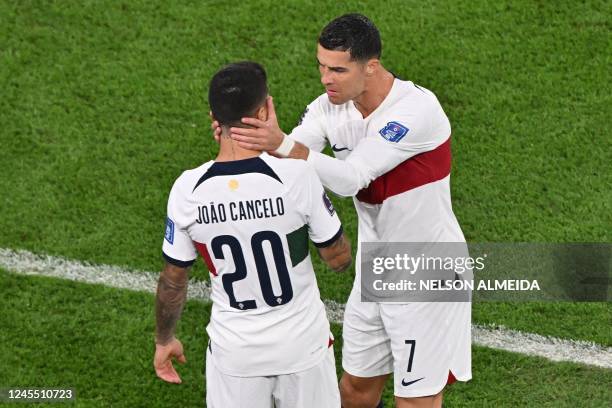 Portugal's forward Cristiano Ronaldo and Portugal's defender Joao Cancelo cheer themselves up before getting onto the pitch on the second-half of the...