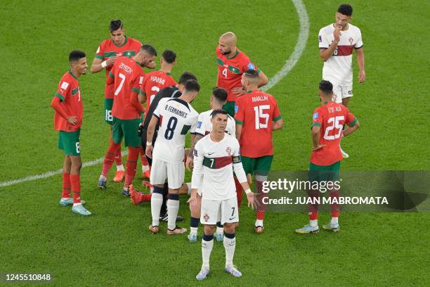 Portugal's forward Cristiano Ronaldo gestures as Morocco's defender Romain Ghanem Saiss lies on the ground after picking up an injury during the...