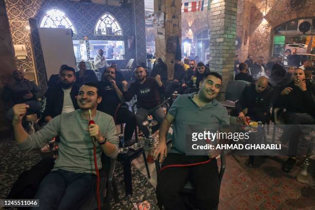 Israeli Arabs celebrate Morocco's opening goal as they watch the Qatar 2022 World Cup football match between Morocco and Portugal, at a coffee shop...