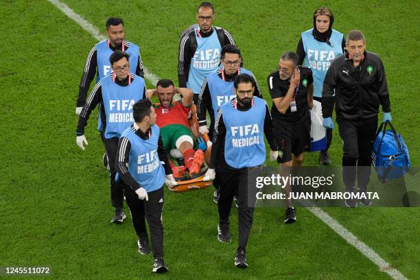 Morocco's defender Romain Ghanem Saiss is taken out of the field to be replaced after picking up an injury during the Qatar 2022 World Cup...