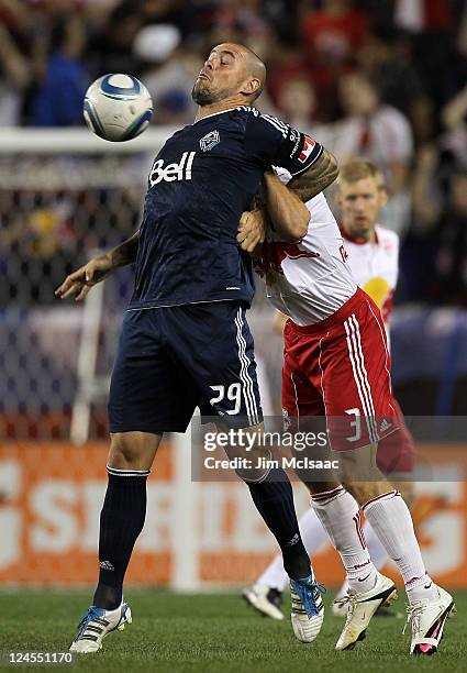 Eric Hassli of the Vancouver Whitecaps FC fights for a loose ball with Chris Albright of the New York Red Bulls at Red Bull Arena on September 10,...