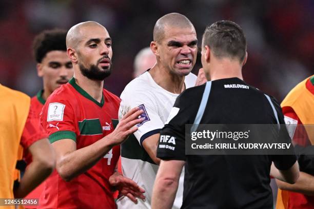 Portugal's defender Pepe argues with Argentinian referee Facundo Tello next to Morocco's midfielder Sofyan Amrabat during the Qatar 2022 World Cup...