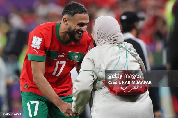 Morocco's midfielder Sofiane Boufal is congratulated by a supporter after his won the Qatar 2022 World Cup quarter-final football match between...