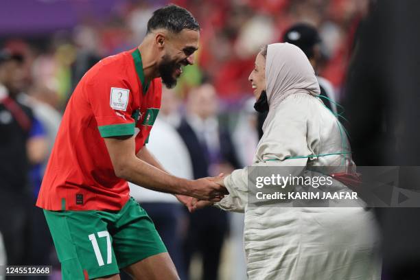 Morocco's midfielder Sofiane Boufal is congratulated by a supporter after his won the Qatar 2022 World Cup quarter-final football match between...