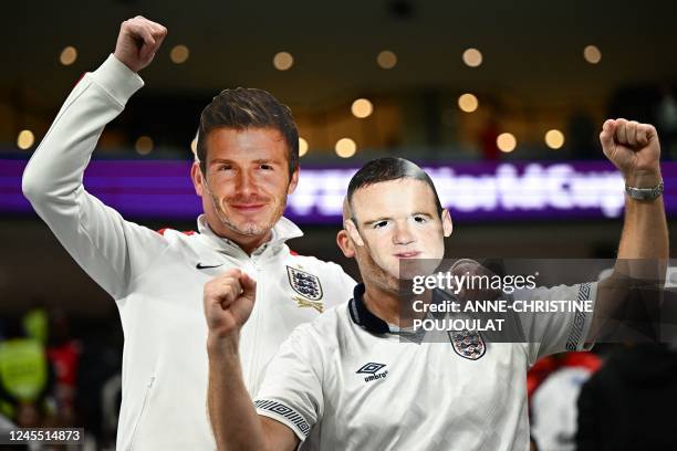 England supporters wera masks of former football players David Beckham and Wayne Rooney as they cheer ahead of the start of the Qatar 2022 World Cup...