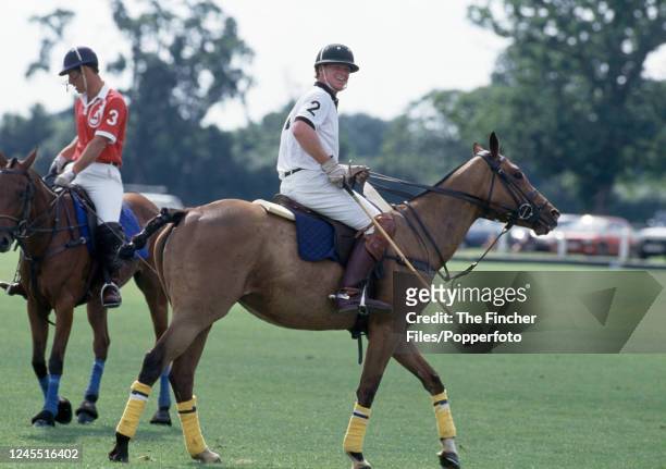 Prince Charles and James Hewitt on horseback during a polo match in which they are playing on opposing teams, at the Royal County of Berkshire Polo...