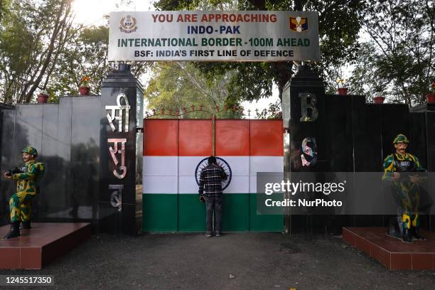 Visitors look towards the gate of international border between India and Pakistan which is painted with Indian National Flag colors or Tri-color in...