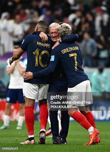 France's coach Didier Deschamps celebrates with France's forward Kylian Mbappe and France's forward Antoine Griezmann after they won the Qatar 2022...