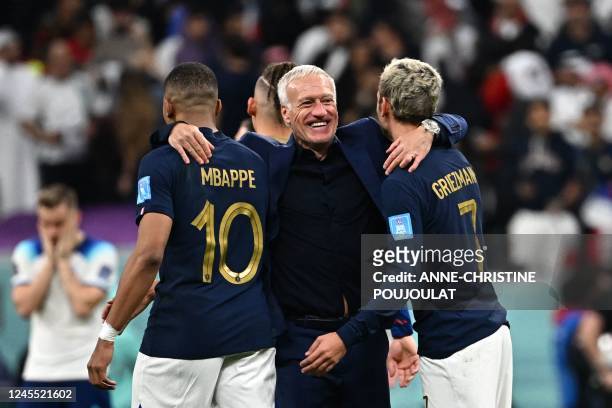 France's coach Didier Deschamps celebrates with France's forward Kylian Mbappe and France's forward Antoine Griezmann after they won the Qatar 2022...