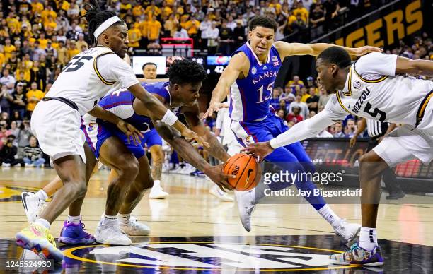 Adams Jr. #24 and Kevin McCullar Jr. #15 of the Kansas Jayhawks fight for a loose ball against Sean East II and D'Moi Hodge of the Missouri Tigers...