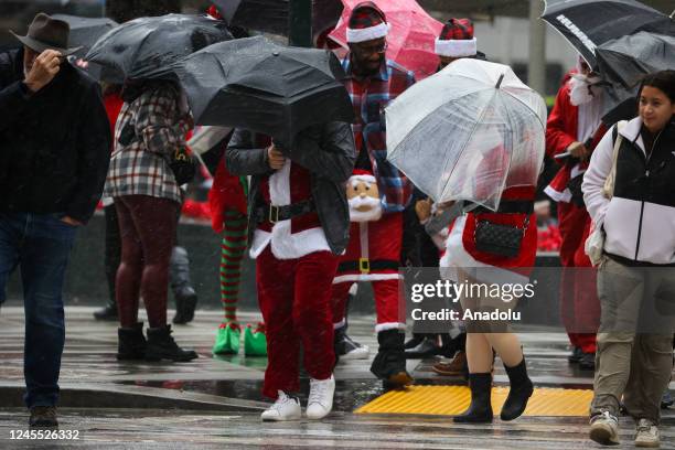 People dressed up as Santa Clause during SantaCon at Union Square despite heavy rain in San Francisco, California, United States on December 10, 2022.