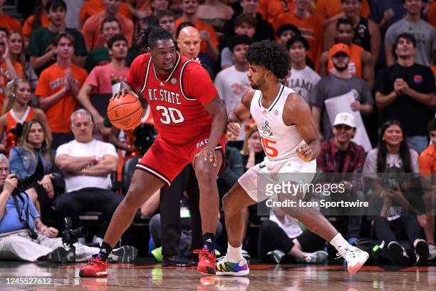 State forward DJ Burns, Jr. Handles the ball while defended by Miami forward Norchad Omier in the first half as the Miami Hurricanes faced the NC...