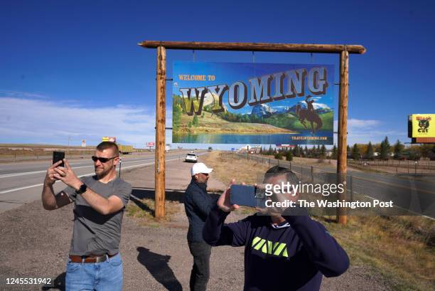 Veterans James Powers, left and Matt Zeller, right, pose for selfies along with Zabih Rauf on the Colorado/Wyoming border on October 21, 2022 near...