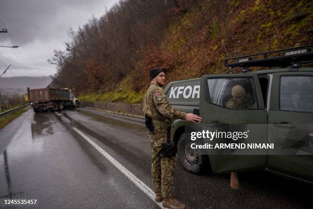 Soldiers serving in the peacekeeping mission in Kosovo inspect a road barricade set up by ethnic Serbs near the town of Zubin Potok on December 11,...