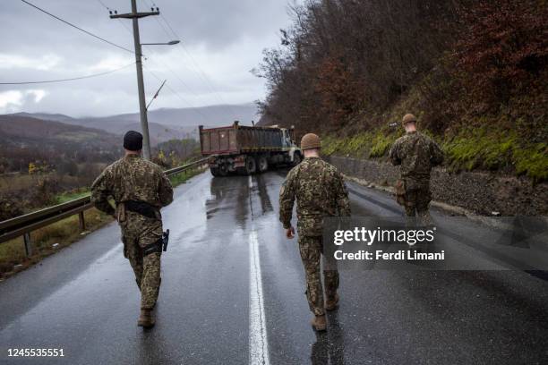 Led Latvian soldiers head to inspect trucks at a roadblock on one of the main roads to the border crossing point with Serbia on December 11, 2022...