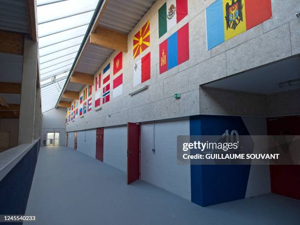 This photograph taken on December 5, 2022 shows flags displayed over the entrance of the 10 meters targets stand at the French National Shooting...