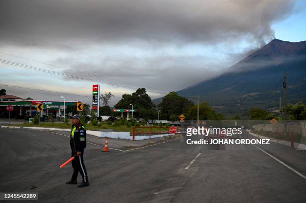 Member of the General Directorate of Road Safety stands next to a closed road after the Fuego volcano erupted, in Alotenango, a municipality in the...
