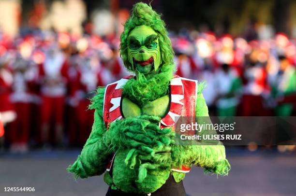 Runner dressed as The Grinch poses for a picture during the the annual "Run Santa Run" Christmas race in Zapopan, Mexico, on December 11, 2022.