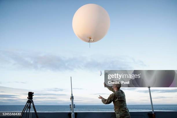 An Air Force member releases a weather balloon off the deck during the recovery operation for NASA's Orion Capsule and uncrewed Artemis I Moon...