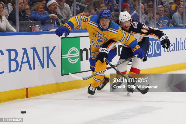 Robert Thomas of the St. Louis Blues looks to beat Samuel Girard of the Colorado Avalanche to the duck in the first period of the game at Enterprise...