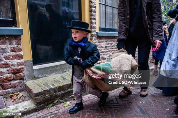 Little child wearing Victorian clothes is seen carrying a big bag during the festival. Each year, around this date, the 19th-century world of the...