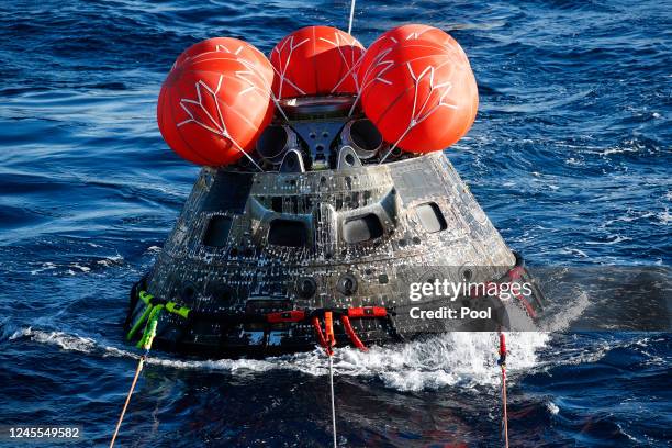 S Orion Capsule of the successful uncrewed Artemis I Moon Mission is drawn toward the U.S.S. Portland on December 11, 2022 in the Pacific Ocean off...