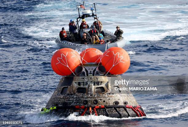 S Orion Capsule is drawn into the well deck of the USS Portland during recovery operations after it splashed down in the Pacific Ocean off the coast...