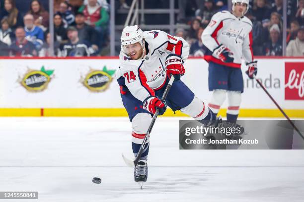 John Carlson of the Washington Capitals shoots the puck down the ice during first period action against the Winnipeg Jets at the Canada Life Centre...