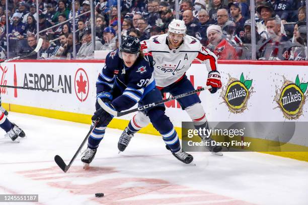 Morgan Barron of the Winnipeg Jets keeps the puck away from John Carlson of the Washington Capitals during first period action at the Canada Life...