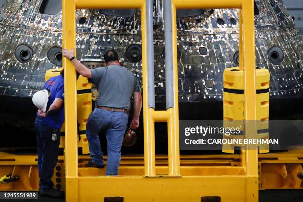 Orion team member inspect NASA's Orion capsule on the USS Portland after being successfully secured off the coast of Baja California, Mexico, on...